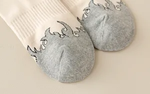 Close-up of beige and grey flame pattern high tube casual cotton socks detailed view.