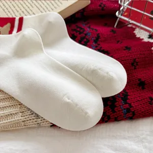 Festive white cotton mid-tube socks featuring cute cartoon dog patterns and red stripes.