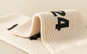 Detail shot of beige ribbed knit fashion socks featuring distinct black number prints.