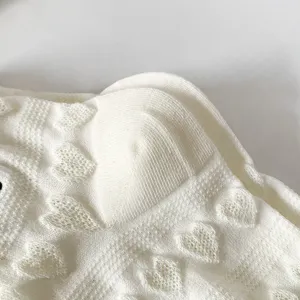 Primo piano di calzini corti bianchi da donna con grazioso motivo a cuori in maglia e morbida.