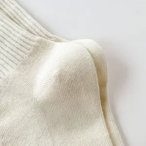 Dettaglio ravvicinato di calzini in cotone a coste bianche, trama fine e comodo design a tubo medio.