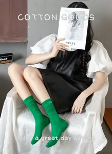 Detail shot of vibrant green ribbed long socks, soft cotton knit texture for cozy autumn wear.