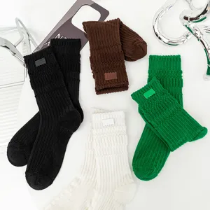 Thickened terry knit long socks with small leather labels in various trendy colors for autumn winter.