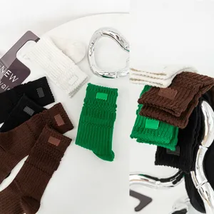 Detailed view of thick thermal looped long socks in multiple colors with leather patch.