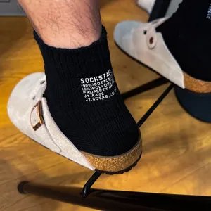 Detail shot of black cotton short socks with letter print, minimalist Japanese style for spring.