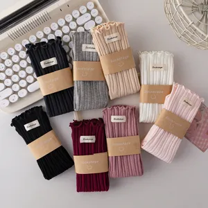 Detail view of multi-color ribbed ruffled cuff mid-tube socks with cute label packaging.