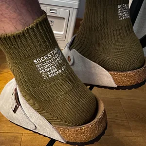 Detail shot of olive green ribbed cotton socks featuring white typography print and cozy texture st.