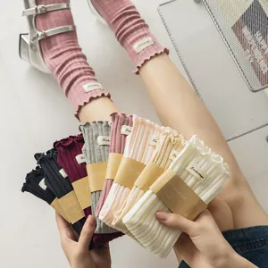 Detail view of women's autumn winter ruffled ribbed slouch socks with cute cloth label.