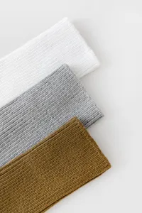 Detailaufnahme von dicken Strick-Baumwollsocken Bündchen in Weiß, Grau und Braun.