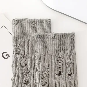 Grey distressed knit socks detailed closeup shot, trendy casual autumn winter hosiery.