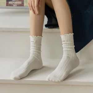 Sweet ruffled white mid-calf socks featuring cozy ribbed design and cute woven label detail.