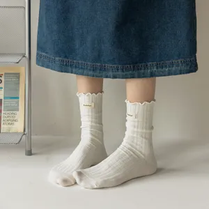 Women's white ribbed mid-tube socks with sweet lettuce edge and cute woven fabric label.