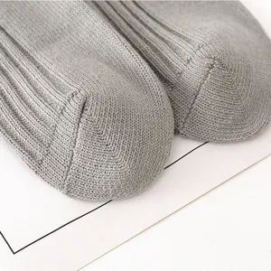 Close up detail view of gray ribbed knit socks, showcasing soft texture and fine craftsmanship.