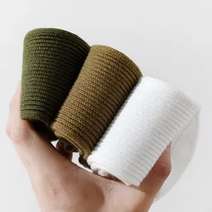 Nahaufnahme der dicken gerippten Socken im Detail, gerollt in gruen braun weiss optik.