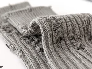 Grey distressed knit socks fabric detail close-up showing soft textured ribbed material.