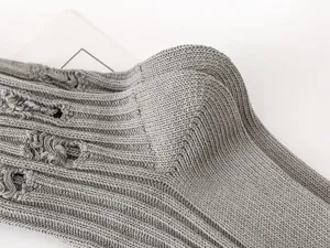 Close-up detail shot of grey distressed knitted socks showcasing unique ripped textured design.