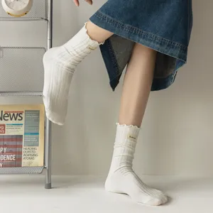 Sweet ruffle edge cotton slouch socks for women, vintage ribbed mid-tube socks with small label.