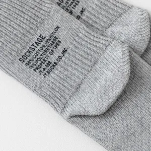 Detailaufnahme von grauen Rippstrick-Baumwollsocken mit modischem Aufdruck und weicher Textur.