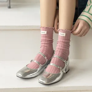 Women sweet lettuce edge vertical stripe slouch socks with cloth label detail shot.