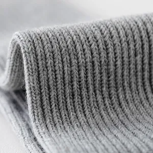 Nahaufnahme der grauen Rippstrick-Gewebebeschaffenheit mit weichen Baumwolldetail.