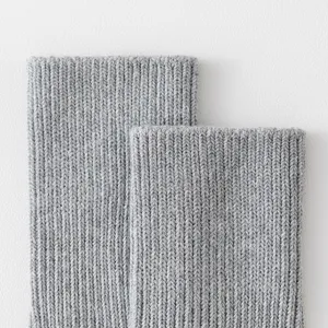 Detaillierte Nahaufnahme der grauen dicken Strickbaumwollsocken mit feiner Rippenstruktur.