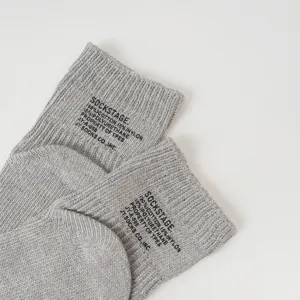 Close-up detail of grey ribbed knit cotton short socks with stylish black letter print.
