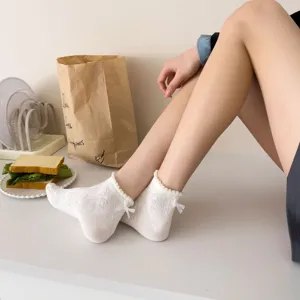 Close-up detail of women's white lace bow mesh short socks, breathable summer style.