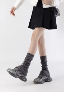 Grijs gebreide beenwarmers met versleten details, trendy JK streetwear accessoire voor de winter.