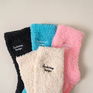 Cozy plush winter socks detail, soft fuzzy fleece texture, delicate letter embroidery.