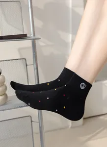Calzini corti neri da donna con pois colorati e grazioso dettaglio ricamato a cuore bianco.