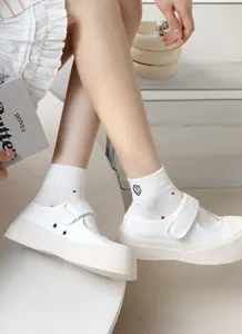 Vista dettagliata di calzini in cotone bianco da donna con ricamo cuore e scarpe casual trendy.