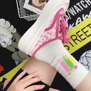 Trendy cotton socks with colorful embroidery paired with stylish pink tweed platform sneakers.