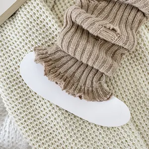 Grofgebreide beenwarmers met versleten details, gezellige winter JK stijl accessoires.
