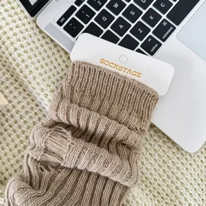 Detailopname van gebonden beenwarmers met gezellige geribbelde textuur en scheuren.