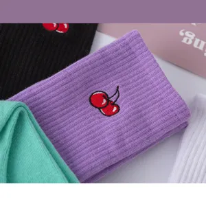 Nahaufnahme von gerippten Baumwoll-Socken für Damen mit süßem gesticktem Kirschen-Motiv.