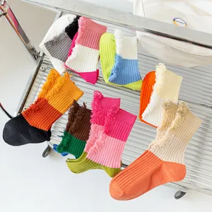 Detailed view of colorful color-blocked distressed mid-calf socks with fringe design for spring.