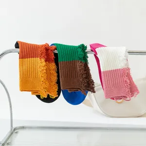 Detailed view of women's color-block distressed mid-calf socks featuring unique frayed patchwork designs.