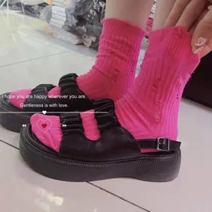 Trendy pink distressed mid-tube socks paired with chic black platform sandals for women.