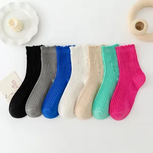 Detail view of colorful ribbed distressed mid-calf socks showcasing unique cozy knit texture.