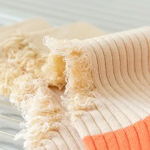 Close-up detail of women's distressed knit socks, showing soft cotton texture and frayed hole design.