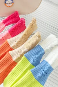 Close-up detail of women color-blocked distressed socks featuring trendy frayed cuffs and vibrant multi-colors.