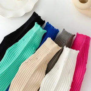 Detail shot of colorful distressed ribbed mid-calf socks showcasing unique knit texture.