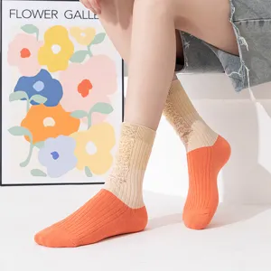 Close-up detail of women's distressed color-block mid-calf socks featuring unique ripped knit style.