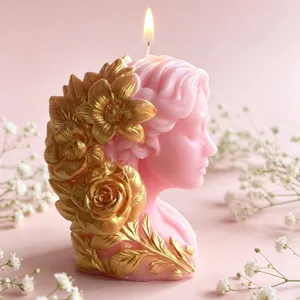 Detail shot of a pink goddess bust scented candle with gold floral relief, glowing wick.