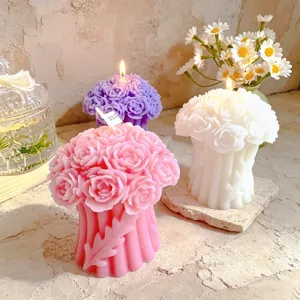 Detailaufnahme von duftenden Rosen-Säulenkerzen in Rosa, Weiß und Lila, schöne Dekoration.