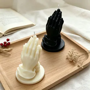 Detailed view of praying hands scented candles on a wooden tray, perfect for home decor.