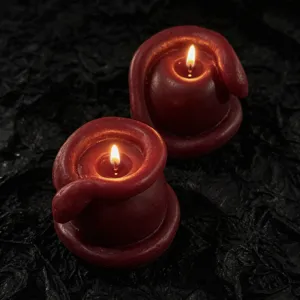 Dark style red snake apple scented candle close up detail showing textured wax and warm flame.