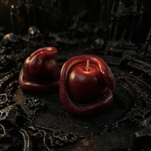 Detail view of dark snake-wrapped apple scented candle, Gothic style wax decor, Halloween detail shot.