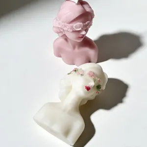 Detailed view of handmade blindfolded bust scented candles, decorative wax sculpture decor.