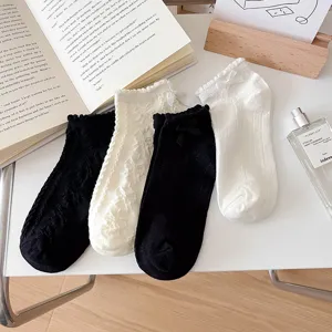 Close-up of women short socks with delicate lace trim and cute bow, hollow design, detail shot.